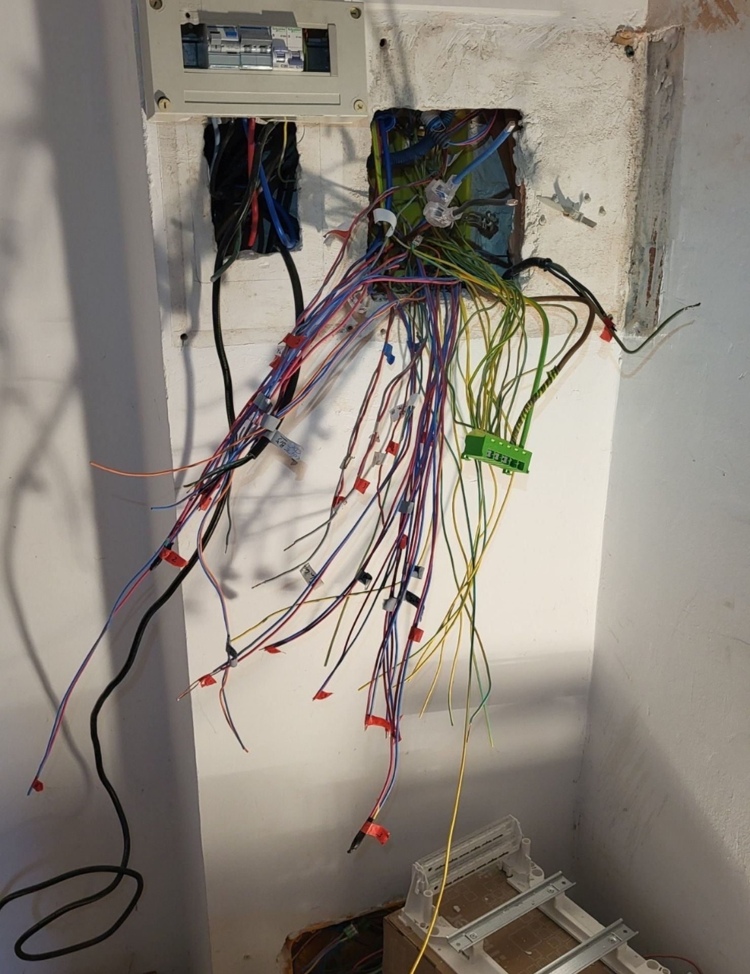 avant tableau électrique Renov’Var (1) Installation électrique en cours avec câblage multicolore, boîtes de jonction et fils étiquetés dans une cloison murale