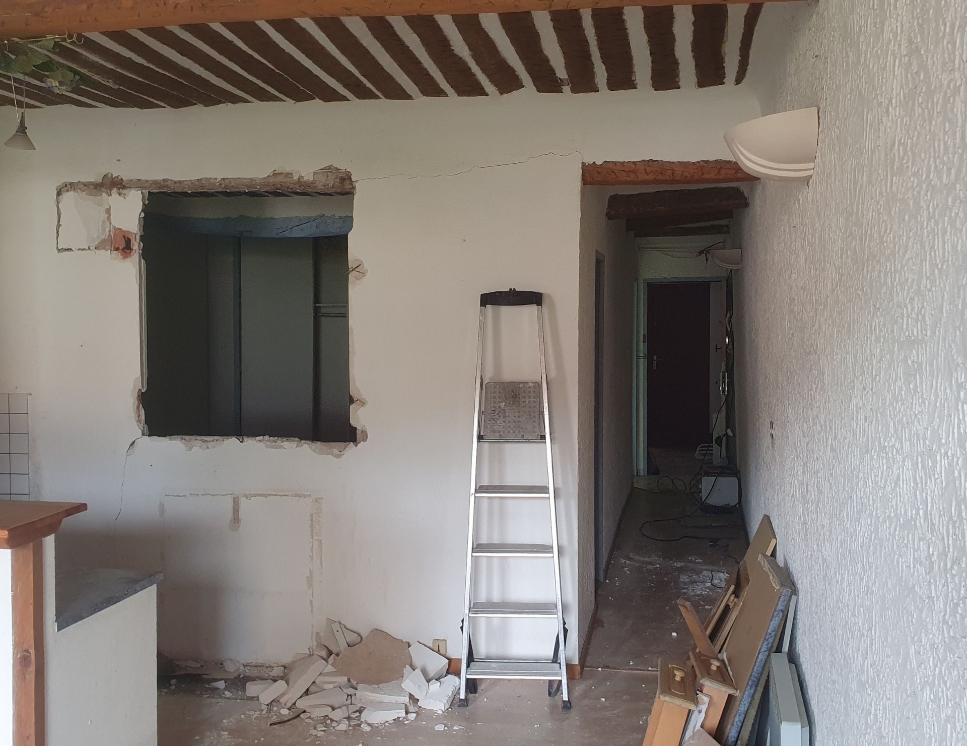 avant verrière Renov’Var Chantier de rénovation intérieure avec démolition, échelle de travail et portes ouvertes sur couloir